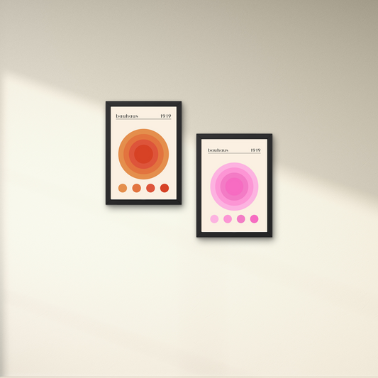 Set of two Bauhaus abstract art prints featuring circular designs in warm orange and pink tones, framed for modern wall decor.




