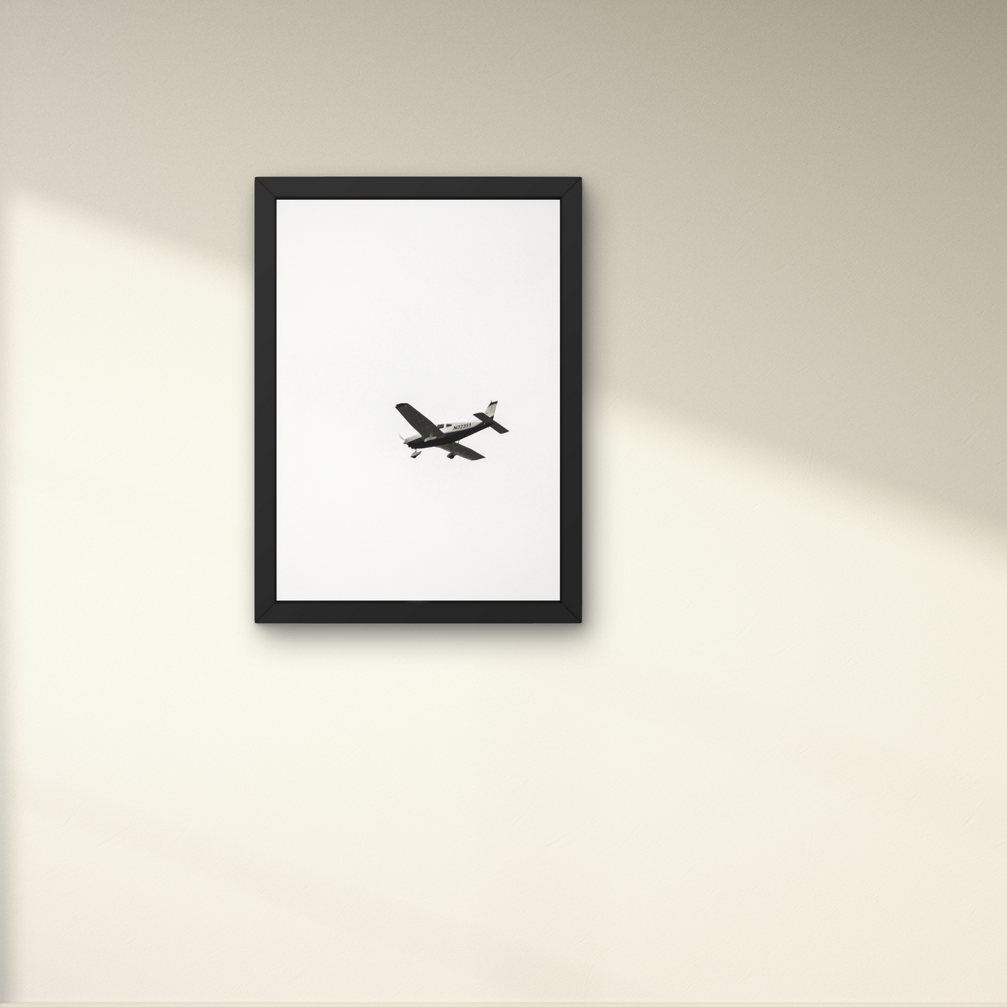 Minimalist wall art featuring an airplane in mid-air against a white background."




